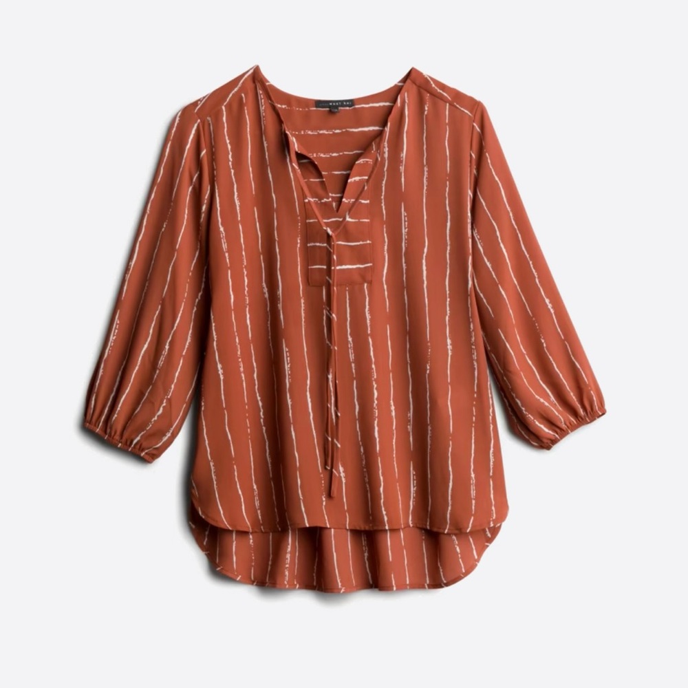 Tie detail blouse. Burnt orange in color. High low hem. V-neck.